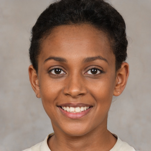 Joyful black young-adult female with short  brown hair and brown eyes