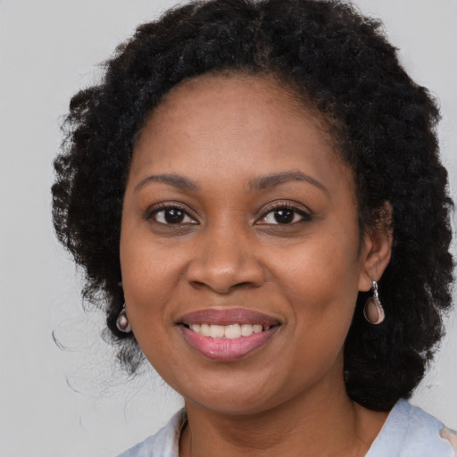 Joyful black adult female with long  brown hair and brown eyes