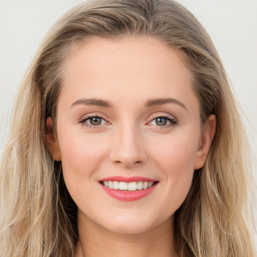 Joyful white young-adult female with long  brown hair and blue eyes