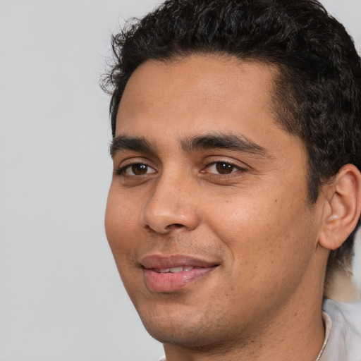 Joyful white young-adult male with short  black hair and brown eyes