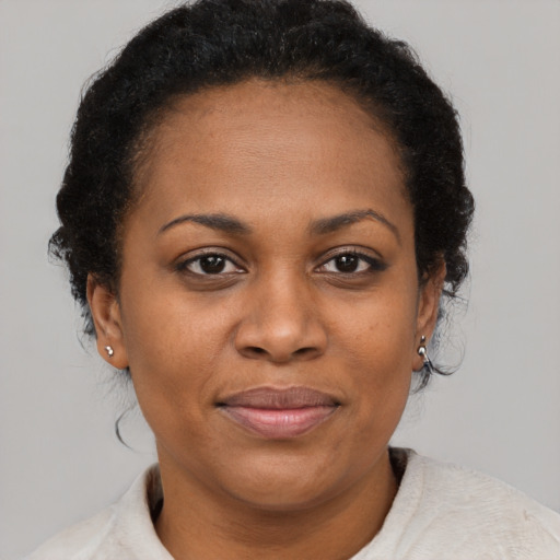 Joyful black adult female with short  brown hair and brown eyes