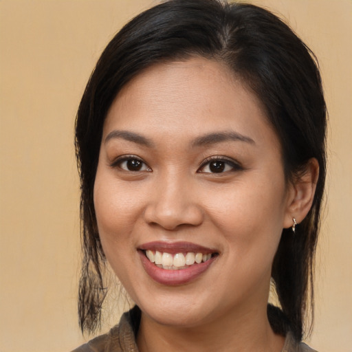 Joyful latino young-adult female with medium  brown hair and brown eyes