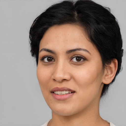 Joyful latino young-adult female with medium  brown hair and brown eyes