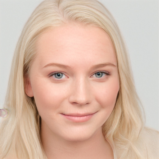 Joyful white young-adult female with long  blond hair and blue eyes