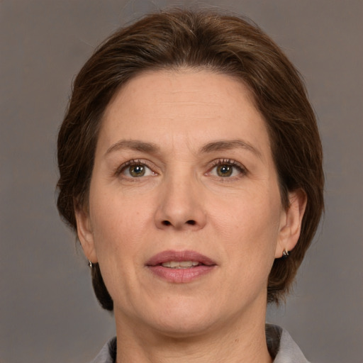 Joyful white adult female with medium  brown hair and grey eyes