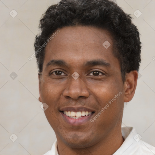 Joyful black young-adult male with short  brown hair and brown eyes