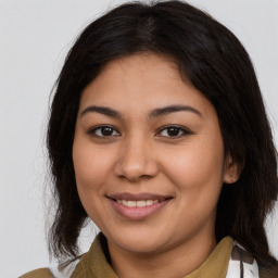 Joyful latino young-adult female with medium  brown hair and brown eyes