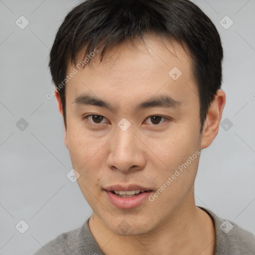 Joyful asian young-adult male with short  brown hair and brown eyes