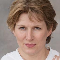 Joyful white adult female with medium  brown hair and blue eyes