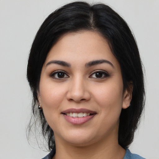 Joyful latino young-adult female with medium  black hair and brown eyes