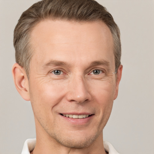 Joyful white adult male with short  brown hair and grey eyes