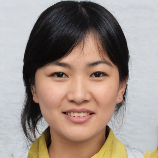 Joyful asian young-adult female with medium  brown hair and brown eyes