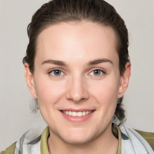 Joyful white young-adult female with short  brown hair and grey eyes