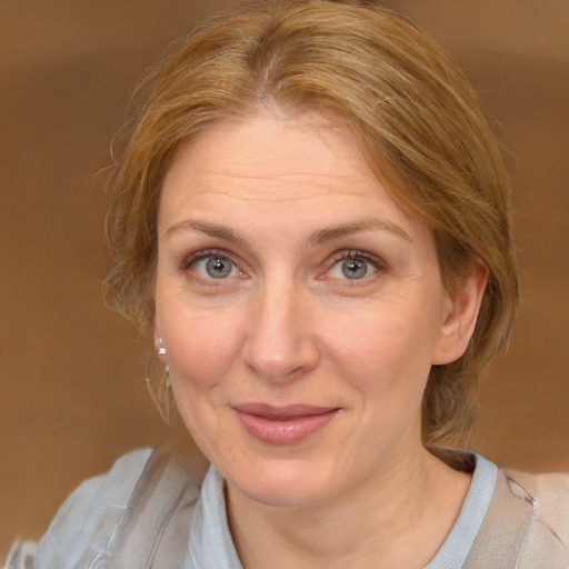 Joyful white adult female with medium  brown hair and blue eyes