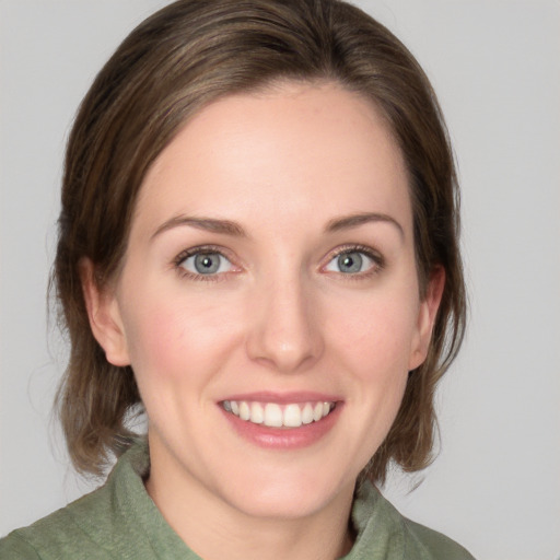 Joyful white young-adult female with medium  brown hair and green eyes