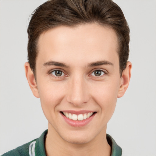 Joyful white young-adult male with short  brown hair and grey eyes