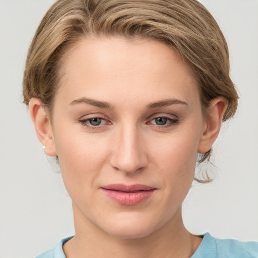 Joyful white young-adult female with medium  brown hair and grey eyes