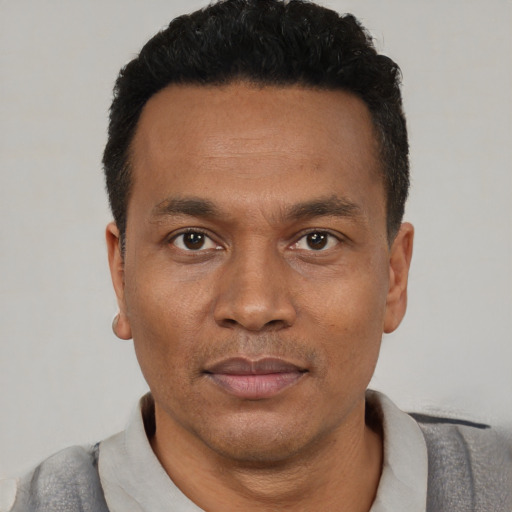 Joyful black young-adult male with short  black hair and brown eyes