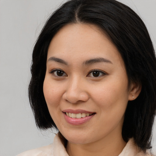 Joyful asian young-adult female with long  brown hair and brown eyes