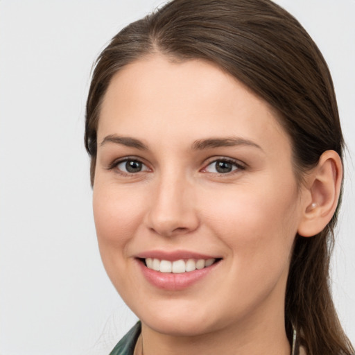 Joyful white young-adult female with long  brown hair and brown eyes