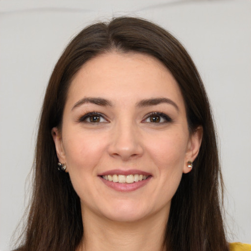 Joyful white young-adult female with long  brown hair and brown eyes