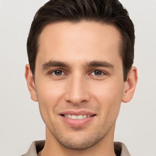 Joyful white young-adult male with short  brown hair and brown eyes