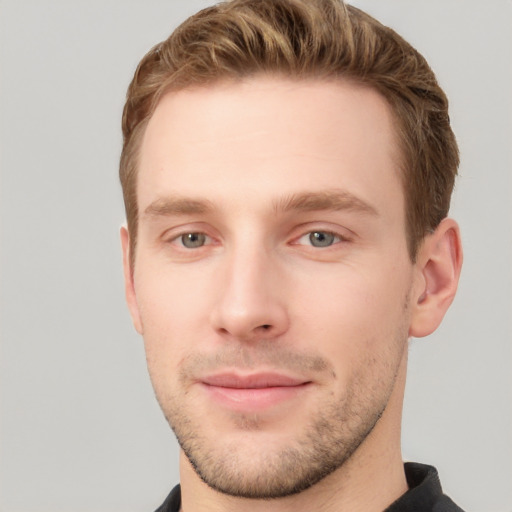 Joyful white young-adult male with short  brown hair and grey eyes