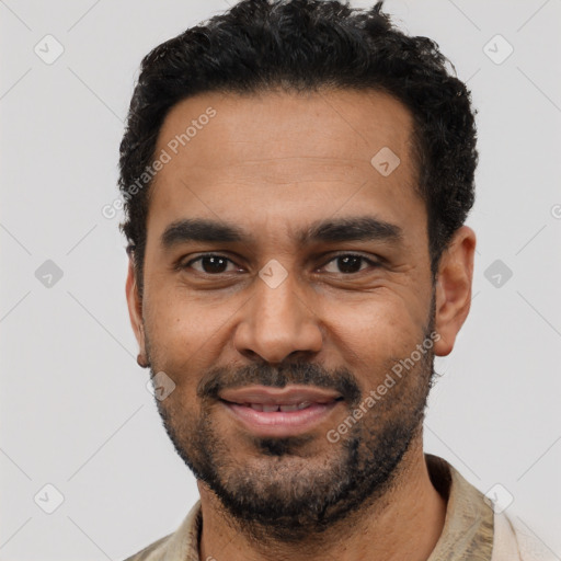 Joyful black young-adult male with short  black hair and brown eyes