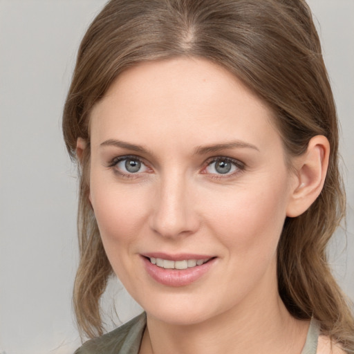 Joyful white young-adult female with medium  brown hair and grey eyes