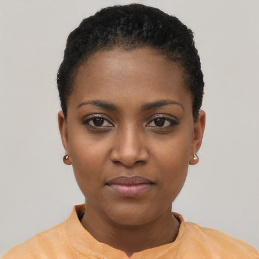 Joyful black young-adult female with short  black hair and brown eyes