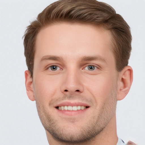 Joyful white young-adult male with short  brown hair and grey eyes