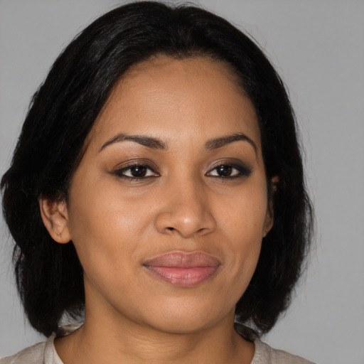 Joyful latino young-adult female with medium  brown hair and brown eyes
