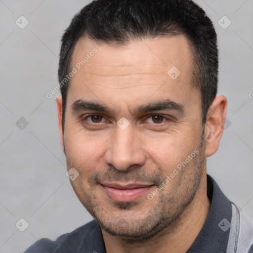 Joyful white adult male with short  black hair and brown eyes