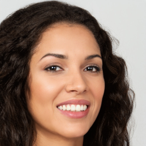 Joyful latino young-adult female with long  brown hair and brown eyes