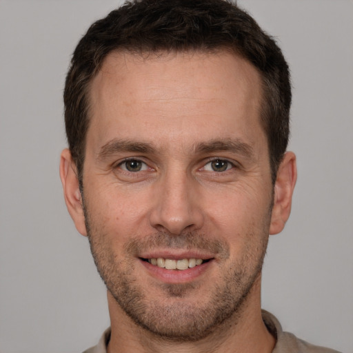 Joyful white adult male with short  brown hair and brown eyes