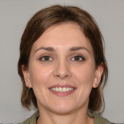 Joyful white young-adult female with medium  brown hair and grey eyes