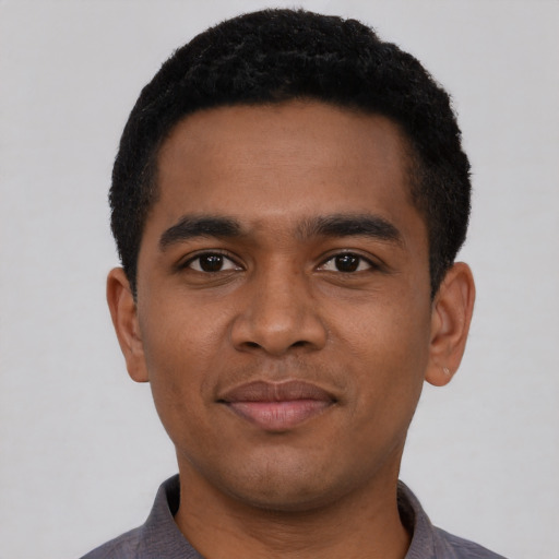 Joyful black young-adult male with short  black hair and brown eyes