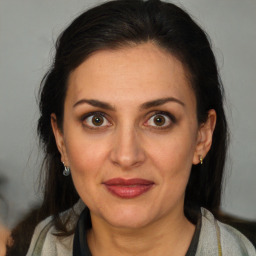 Joyful white adult female with long  brown hair and brown eyes