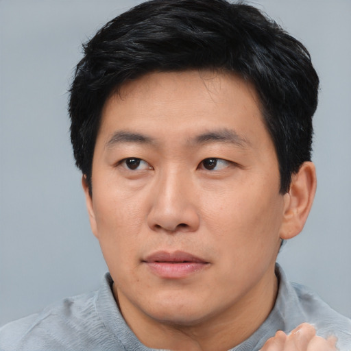 Neutral asian adult male with short  brown hair and brown eyes