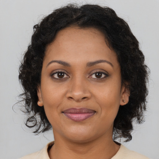 Joyful black young-adult female with medium  brown hair and brown eyes