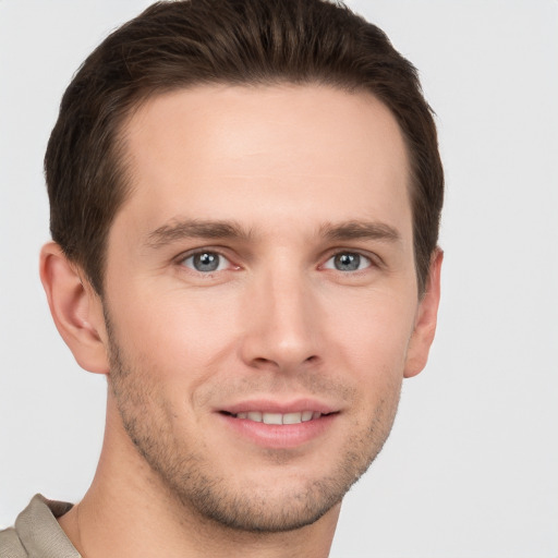 Joyful white young-adult male with short  brown hair and grey eyes