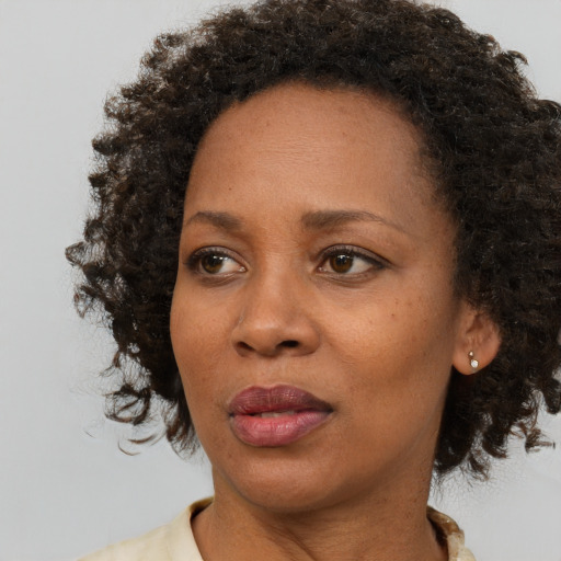 Joyful black adult female with medium  brown hair and brown eyes