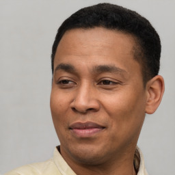 Joyful latino adult male with short  brown hair and brown eyes