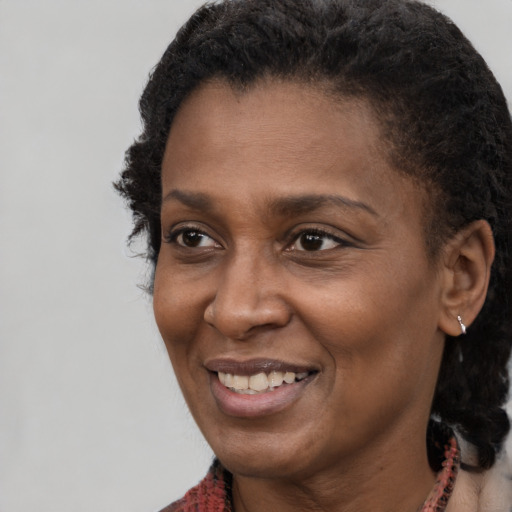 Joyful black young-adult female with short  brown hair and brown eyes