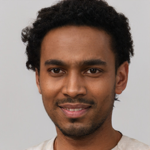 Joyful black young-adult male with short  black hair and brown eyes