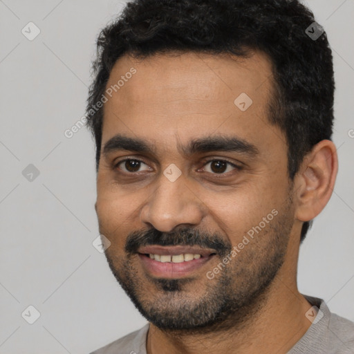 Joyful latino young-adult male with short  black hair and brown eyes