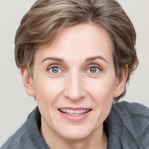 Joyful white adult female with medium  brown hair and grey eyes