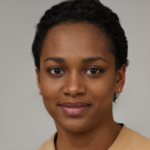 Joyful black young-adult female with short  black hair and brown eyes