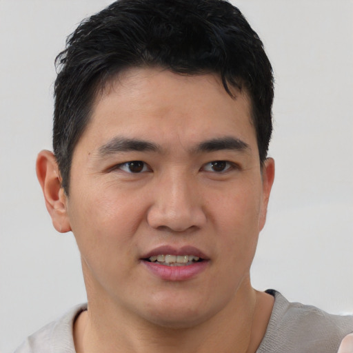 Joyful white young-adult male with short  black hair and brown eyes