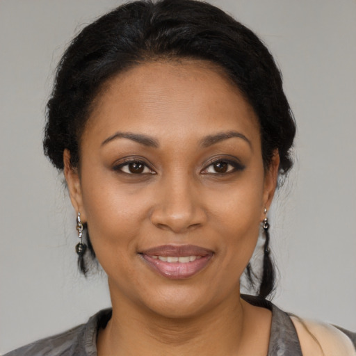 Joyful black adult female with medium  black hair and brown eyes